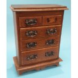 A miniature oak chest of two short and three long graduated drawers