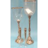 A pair of hurricane lamps and a pair of tall slender candlesticks