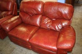 A burgundy leather three seater settee and a two seater settee and an armchair (recliners)