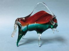 A Murano buffalo of red, green and clear glass, 25cm wide