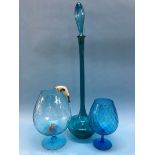 A very tall blue glass bottle and stopper and two blue glass brandy balloons, with cat and mouse,
