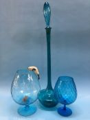 A very tall blue glass bottle and stopper and two blue glass brandy balloons, with cat and mouse,