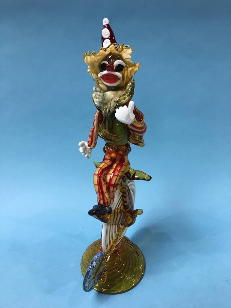 A large Murano glass figure of a clown riding a penny farthing style bike, in multi colours, 48cm