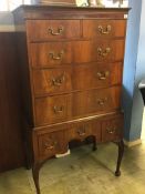 A walnut chest on stand with two short and three long drawers, below three short drawers