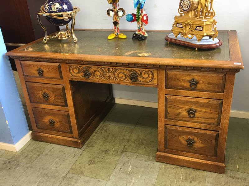 An oak pedestal desk with green inset leather top and seven drawers, 152 x 76cm