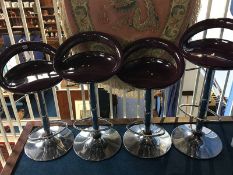 A set of four purple and chrome bar stools