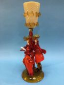 A Murano figural glass table lamp of two ladies wearing orange, below a caramel coloured shade, 52cm