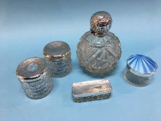 A large silver topped scent bottle, three matching silver top bottles and an enamelled silver and