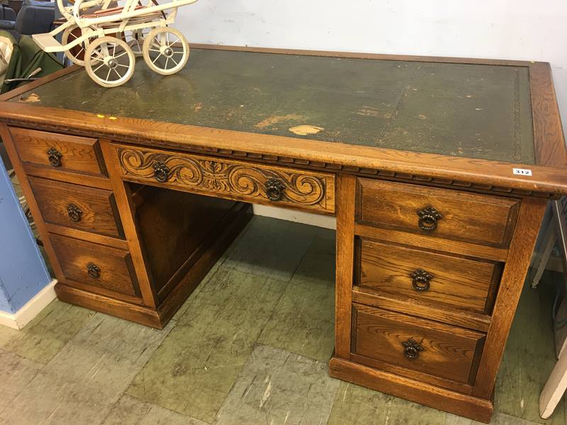 A carved oak pedestal desk