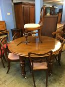 A Victorian mahogany extending table with three leaves and a selection of ten chairs