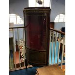 A Louis XV style standing corner cabinet with bow front and glazed doors