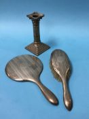A Corinthian silver candlestick and a silver backed mirror and brush