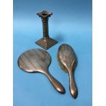 A Corinthian silver candlestick and a silver backed mirror and brush