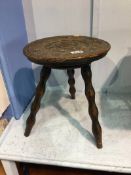 A carved oak circular stool