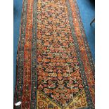 A 1930’s Hamadan Persian runner, the midnight blue ground strewn with geometric floral medallions in