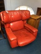 A large red leather swivel armchair with matching footstool