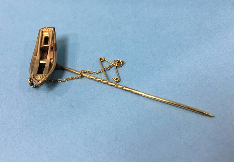 A pin in the form of a rowing boat, stamped 9ct, 1.9g