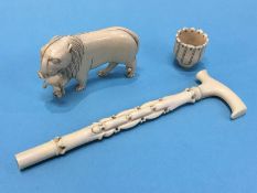 A miniature ivory walking cane and a carved lion