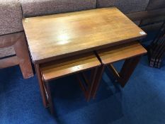 A teak fold over top nest of tables