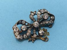 A diamond mounted brooch in the form of a bow 2.8cm wide 1.9cm high Weight 4.3 grams White and