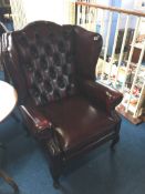 An Oxblood Chesterfield wing back armchair