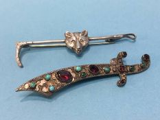 A Foxes head and riding crop brooch, stamped silver and a Middle Eastern brooch mounted with