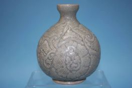 A bulbous celadon vase, with carved leaf decoration, 20cm high