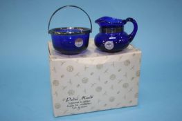A boxed Holmegaard blue glass cream jug and sugar bowl