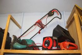 A shelf of gardening equipment, including lawnmower and strimmer