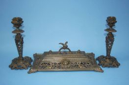 A pierced brass inkwell and a pair of candlesticks