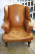 A large tan brown leather armchair