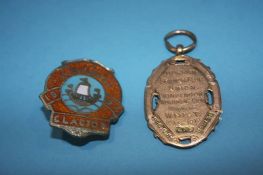 A 9ct gold medallion, 8.4g, together with an enamelled Butlins badge