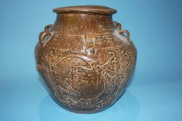 A large Oriental brown glaze and earthenware vase, decorated with dragons, 30cm high