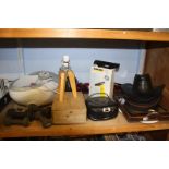 A shelf of miscellaneous including a footbath and a selection of hats