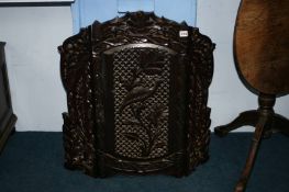 A carved hardwood fire screen and one other