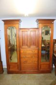 An Edwardian inlaid mahogany wardrobe, two mirror doors, either side of cupboard, over four drawers,