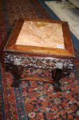 A carved Oriental hardwood plant stand with inlaid marble top, 46cm tall