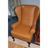 A tan leather John Lewis wing armchair