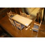 A miniature wooden table and six chairs
