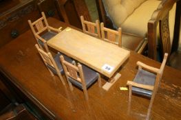 A miniature wooden table and six chairs