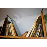 A shelf of framed pictures and prints