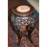 A carved Oriental hardwood plant stand with inlaid marble top, 69cm tall