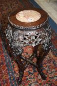 A carved Oriental hardwood plant stand with inlaid marble top, 69cm tall