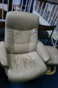 A beige leather swivel chair and footstool
