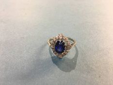 A diamond and sapphire mounted white metal ring, the central sapphire 8.1mm x 7.4mm