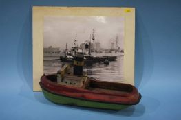 A wooden model of a tug boat with a photograph of the tub boat, 'Cullercoats'