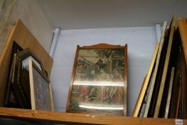 A shelf of framed pictures, mirror etc.