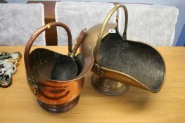 A copper coal scuttle and a brass coal scuttle