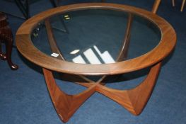 A teak circular glass top coffee table