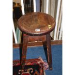 A wooden circular topped stool